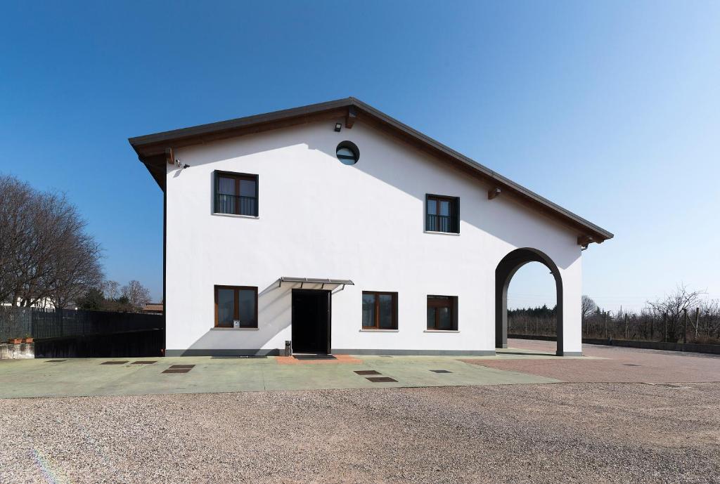 維洛納的住宿－Agriturismo Le Grazie，一座白色的大建筑,有黑色的门道