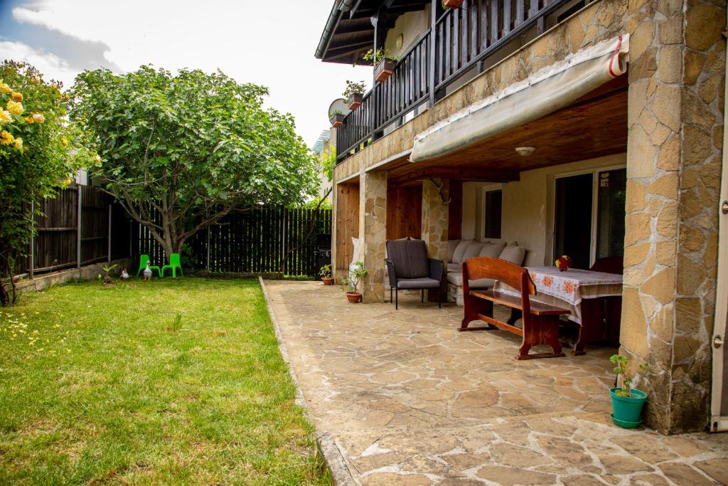 um pátio com uma mesa e cadeiras ao lado de uma casa em Villa Beni ~ 4-Bedroom Private House em Lozenets