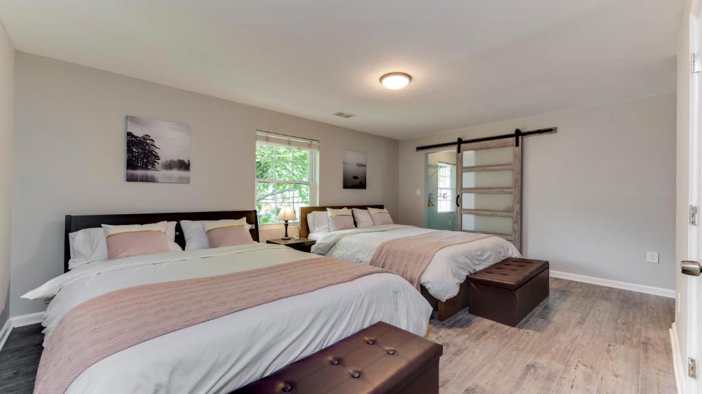 a bedroom with two beds and a window at Stylish 3BR 3BA Colonial House by CozySuites in Alexandria
