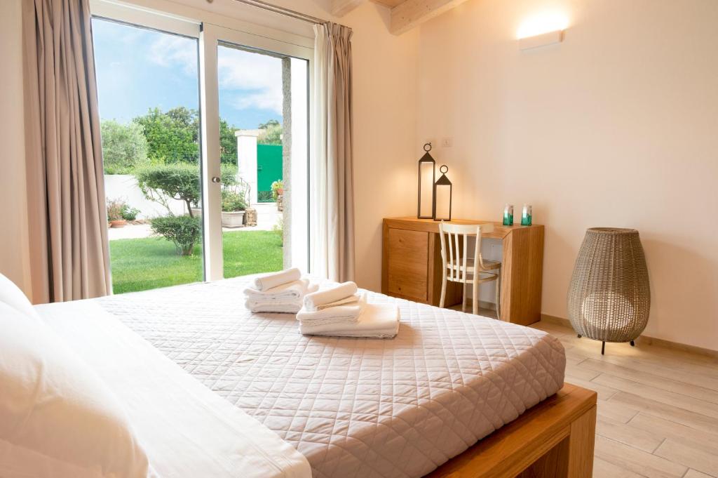 a bedroom with a large bed with towels on it at Villa Summer Luxury Apartment in Olbia