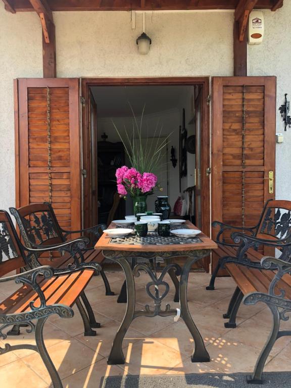 una mesa con un jarrón de flores en un patio en Balaton Vendégház Paloznak, en Paloznak