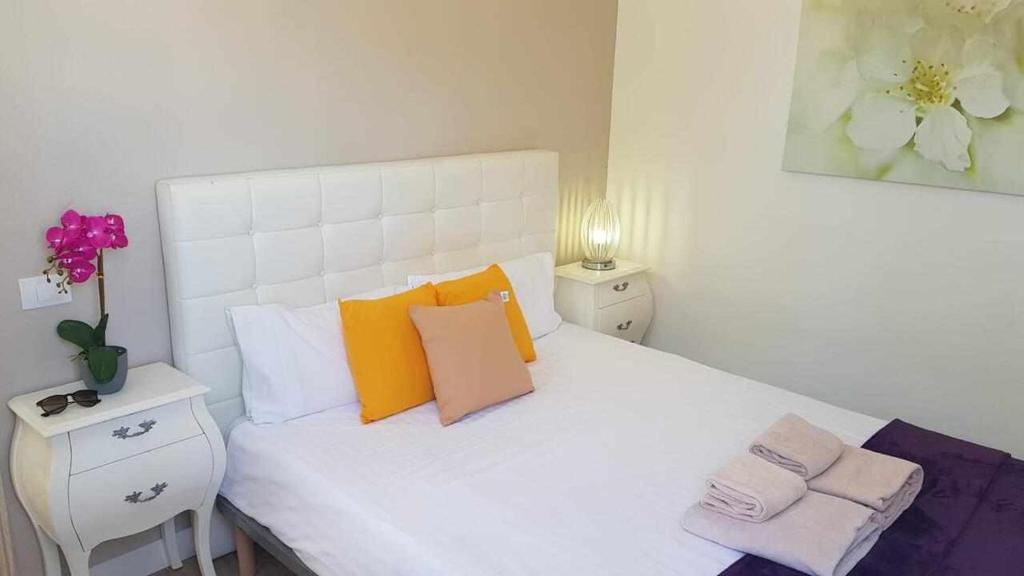 a bedroom with a white bed with colorful pillows at Apartamento Talay 1 in Corralejo