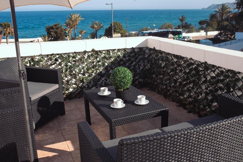 a patio with a table and chairs and the ocean at Mariam Mojácar Apartment in Mojácar