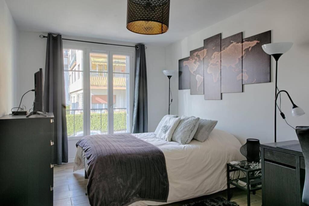 a bedroom with a bed and a large window at Charme et Confort pour vos vacances sur Nice in Nice