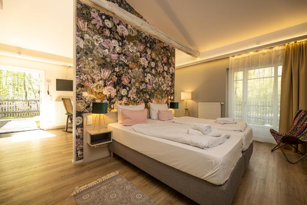 1 dormitorio con 1 cama grande y pared de flores en Little Suite Apartments, en Dresden