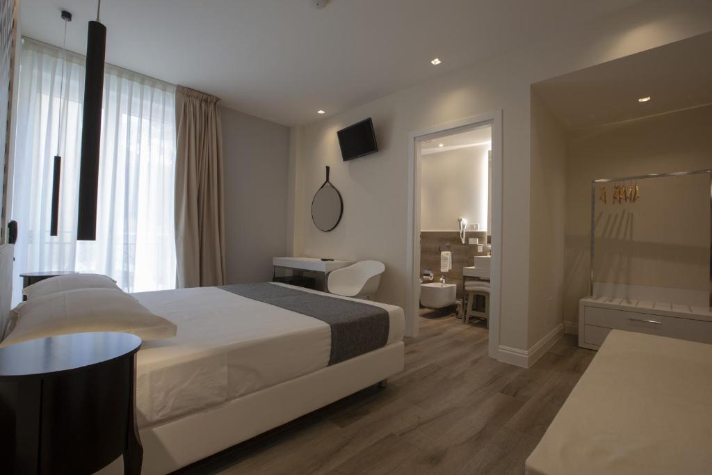a hotel room with a bed and a desk at Luxmarì Hotel & Spa in Castellammare del Golfo