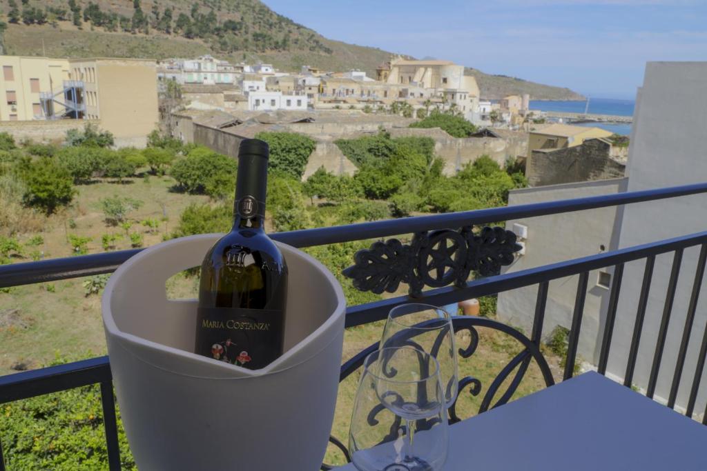 a bottle of wine in a holder on a balcony at Luxmarì Hotel & Spa in Castellammare del Golfo