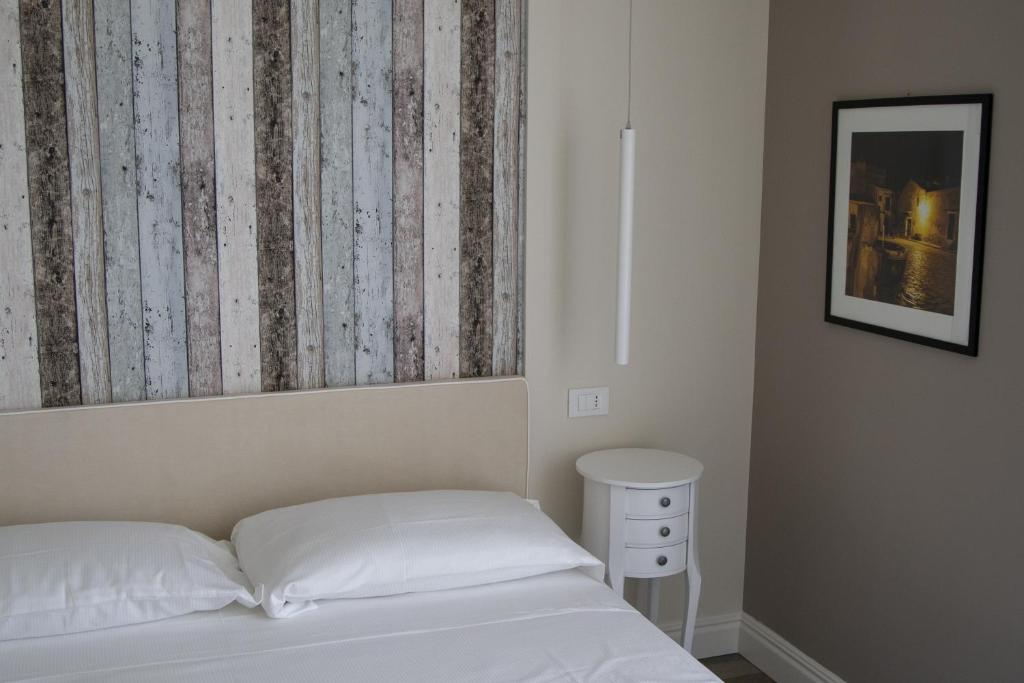 a bedroom with a white bed and a curtain at Luxmarì Hotel & Spa in Castellammare del Golfo