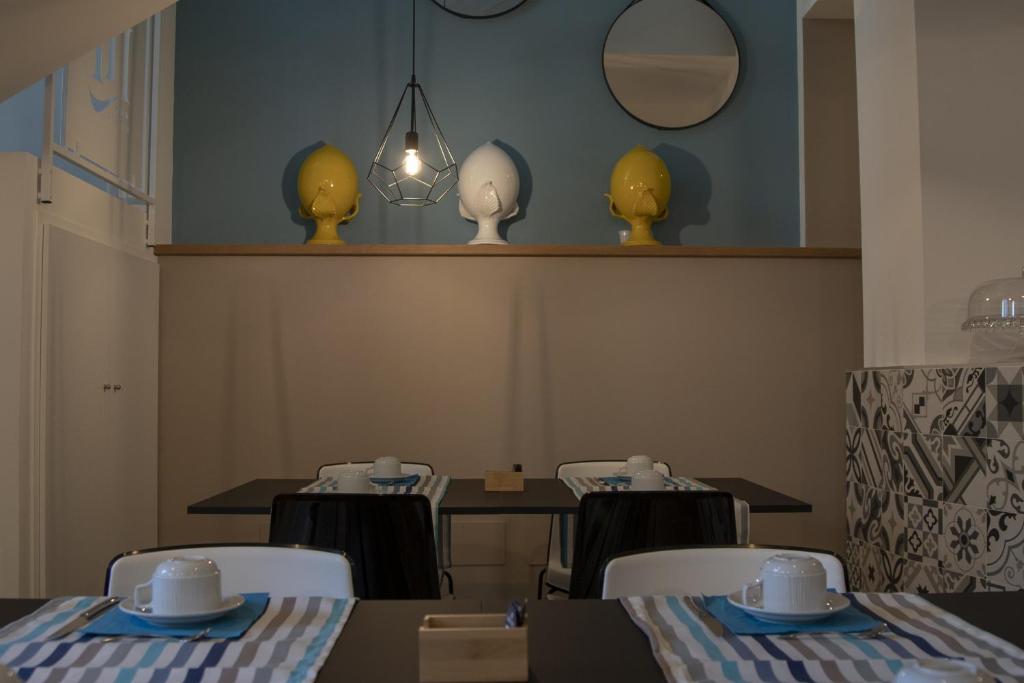 a dining room with a table and chairs and a mirror at Luxmarì Hotel & Spa in Castellammare del Golfo