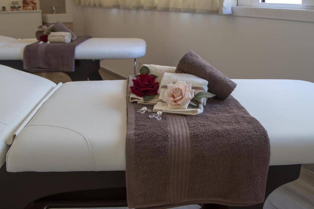 a bed with two pillows and a tray with flowers on it at Luxmarì Hotel & Spa in Castellammare del Golfo