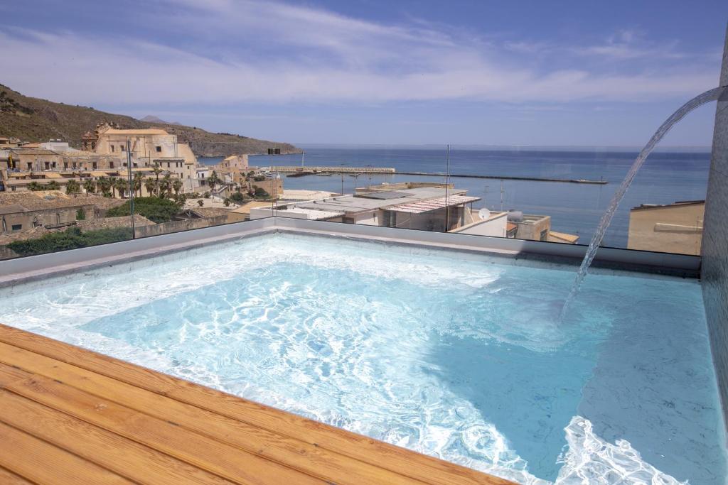 a swimming pool with a view of the ocean at Luxmarì Hotel & Spa in Castellammare del Golfo