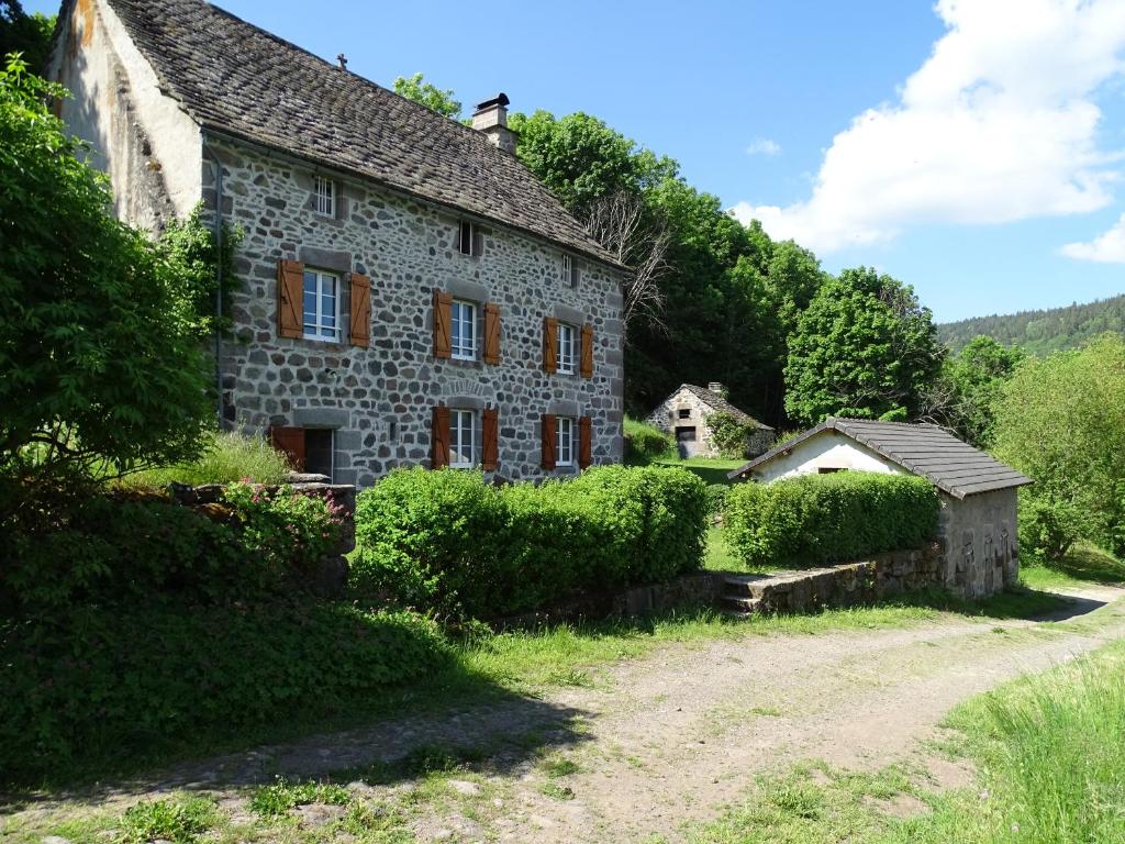 una vieja casa de piedra en medio de un campo en gite du cresponnet, en Murat