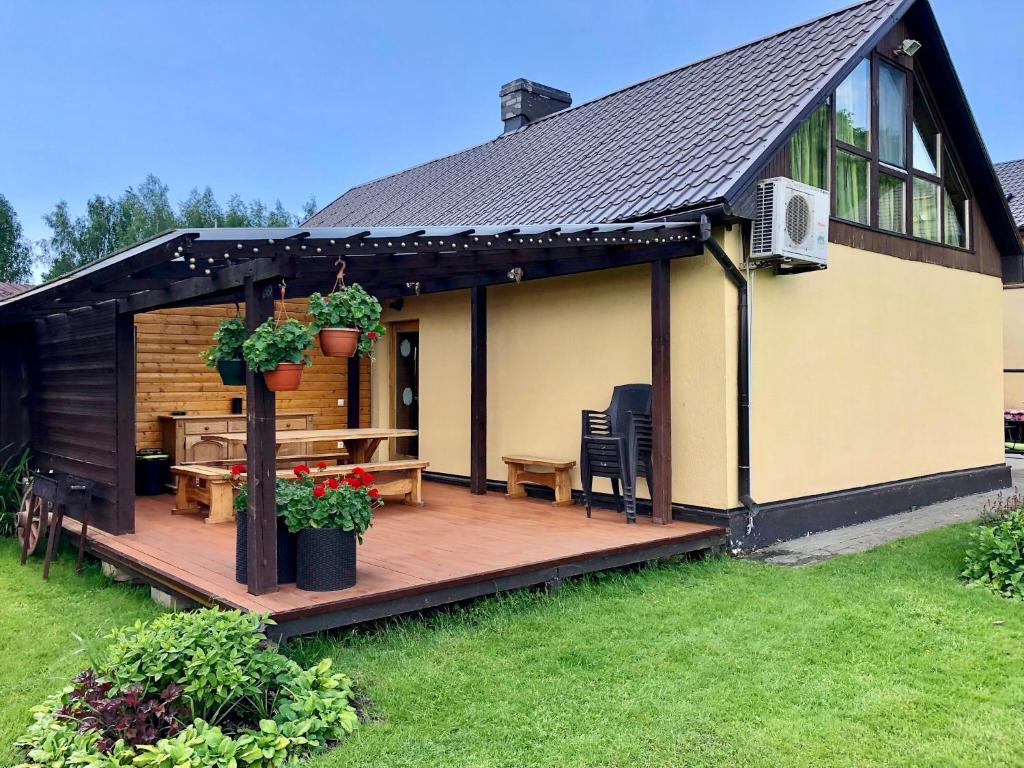 ein Haus mit einer Holzterrasse mit einem Tisch in der Unterkunft Brīvdienu mājas Pārupes in Bauska