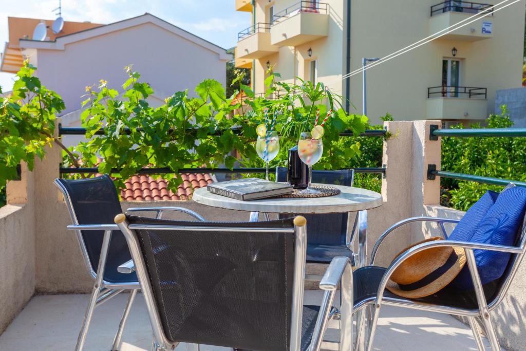 Sea and Lemon Tree apartment في Drašnice: طاولة خارجية عليها كراسي ومزهرية