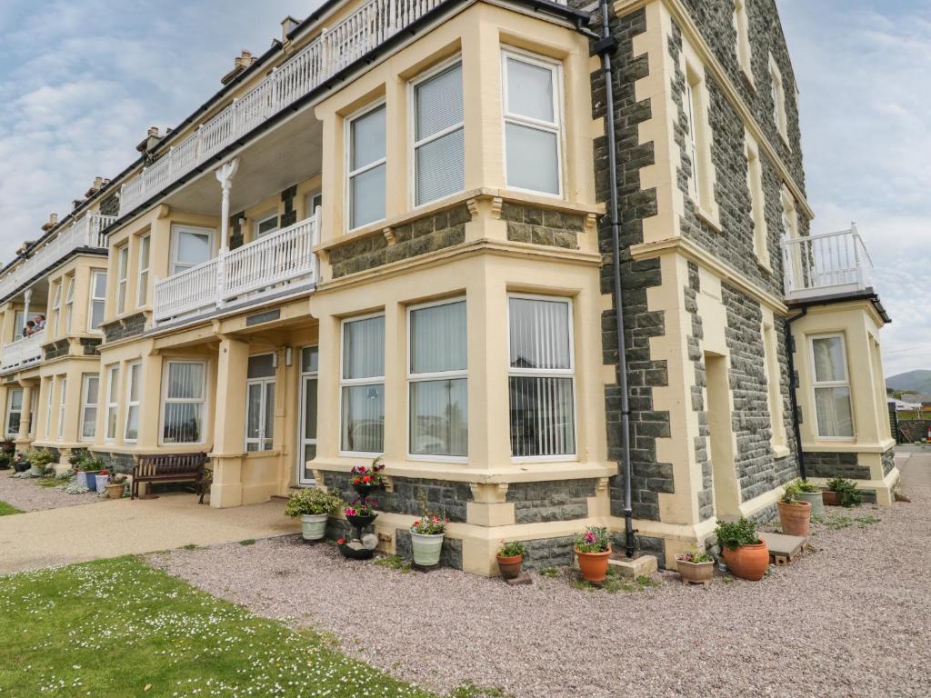 a large building with potted plants in front of it at The Nook in Tywyn