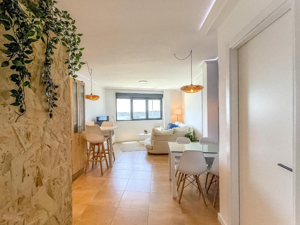 a living room and dining room with a table and chairs at Apartamento Dique Guardes in A Guarda