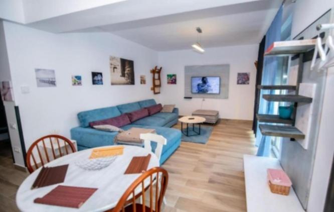 ein Wohnzimmer mit einem blauen Sofa und einem Tisch in der Unterkunft Antonia Apartment Marina Surf Residence in Mamaia Nord – Năvodari