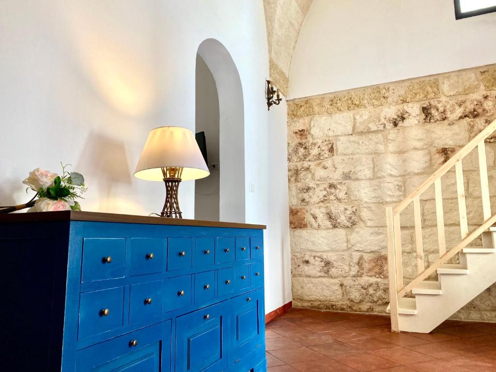 una camera con cassettiera blu e lampada in cima di Ca Strignano Suite, Typical House a Castrignano del Capo