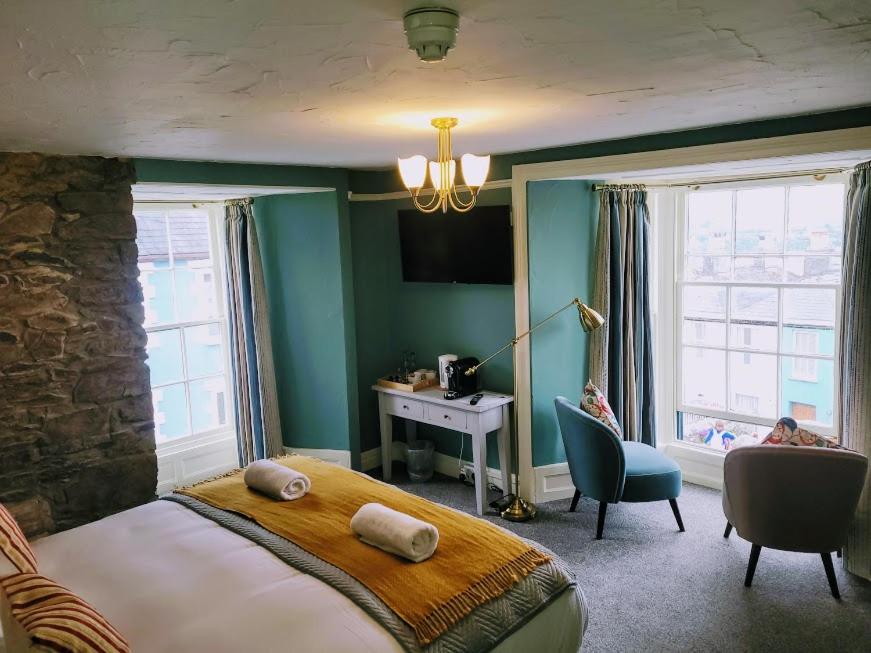 a bedroom with a large bed and a desk and window at Jacobs Ladder Inn in Falmouth