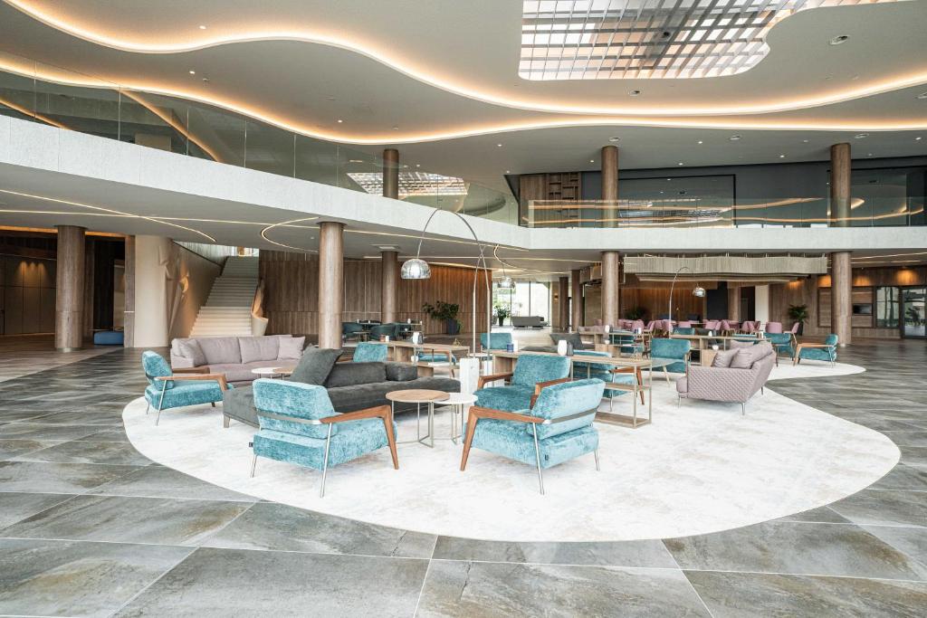 a lobby with chairs and tables in a building at HVD Reina del Mar - Premium Spa Service & Free Parking in Obzor