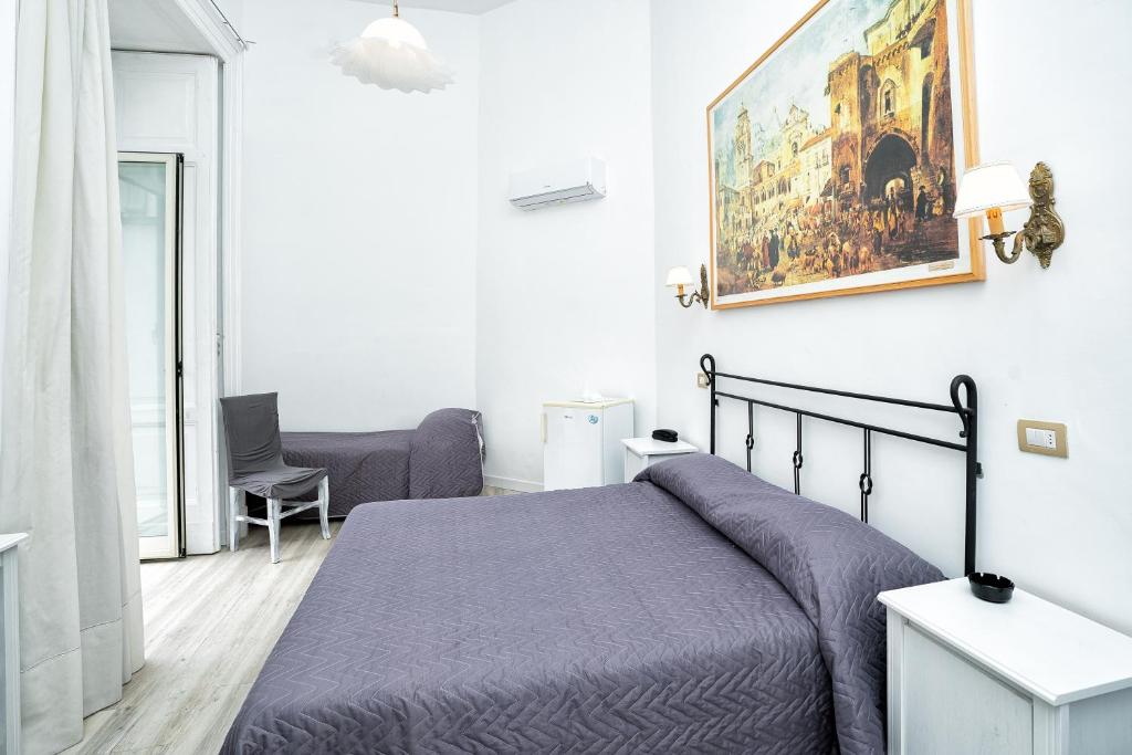 a bedroom with a bed and a painting on the wall at Hotel Fontana in Amalfi