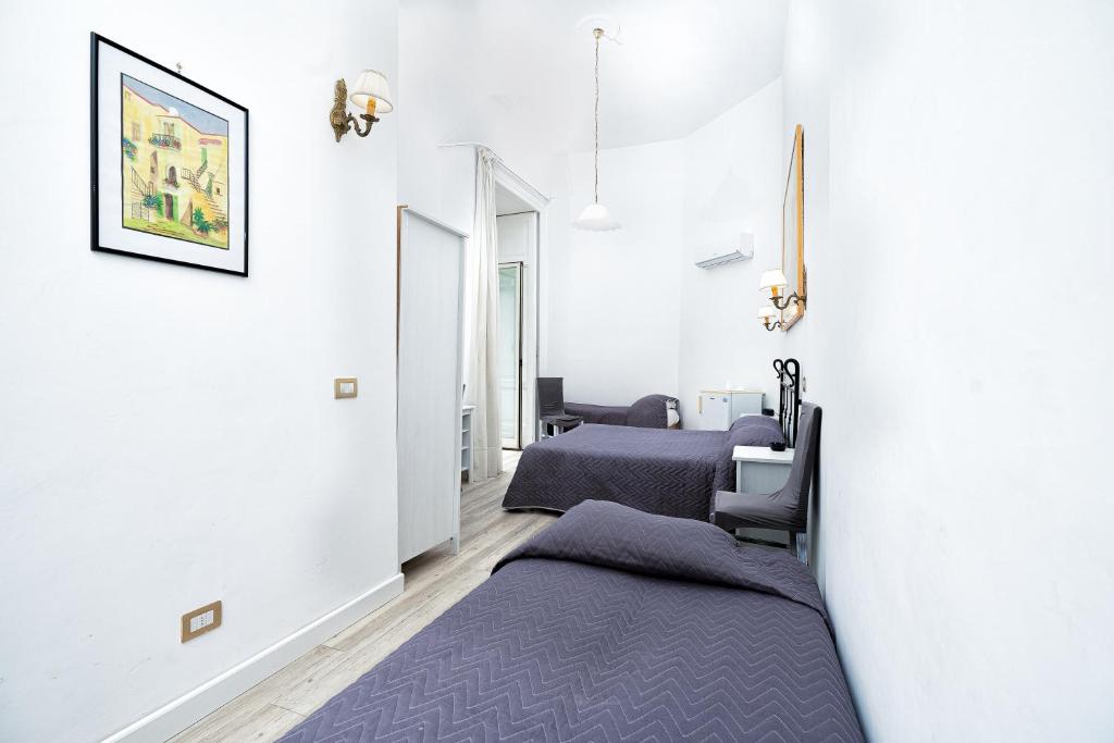 a row of beds in a room with white walls at Hotel Fontana in Amalfi