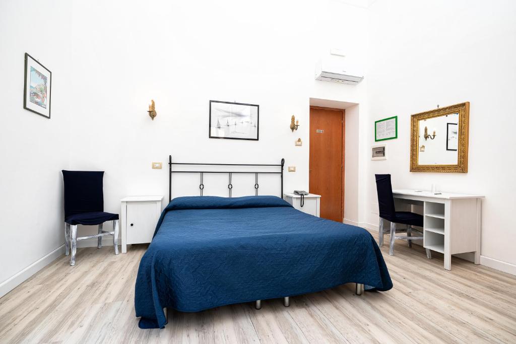 a bedroom with a bed and a desk and chairs at Hotel Fontana in Amalfi
