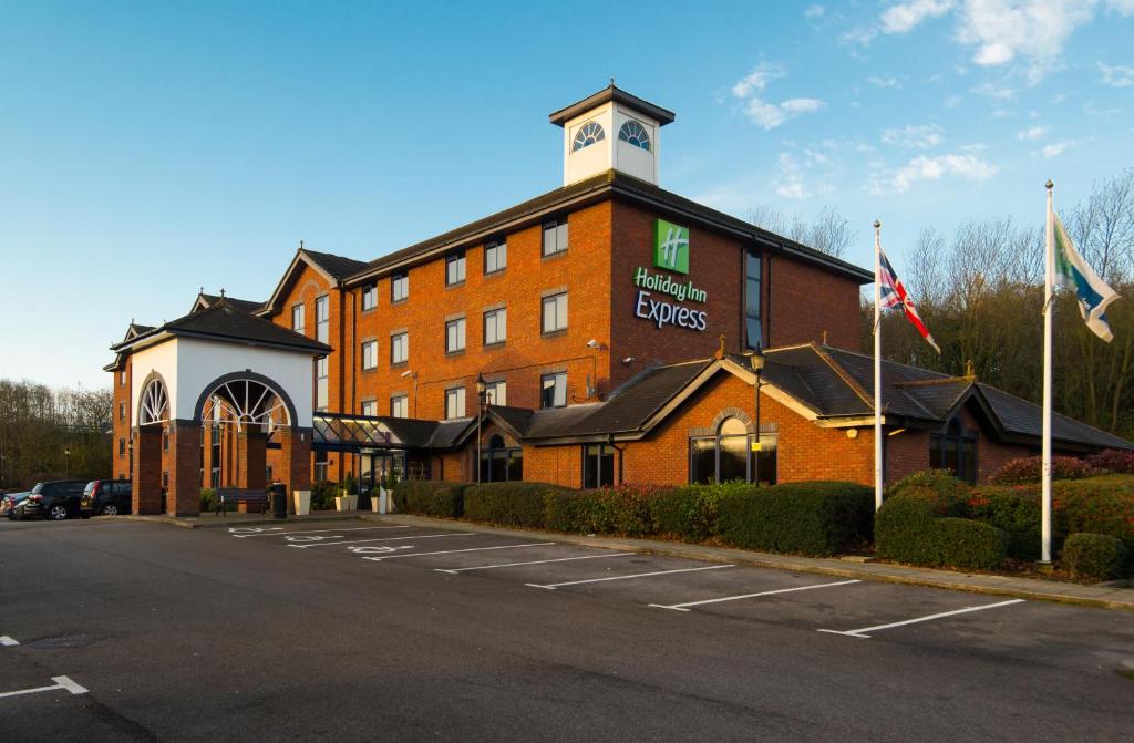 Holiday Inn Express Stafford, an IHG Hotel في ستافورد: مبنى من الطوب الأحمر كبير مع برج الساعة