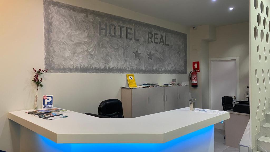 a room with a white counter with a hotel real sign on the wall at Hotel Real Castellon in Castellón de la Plana