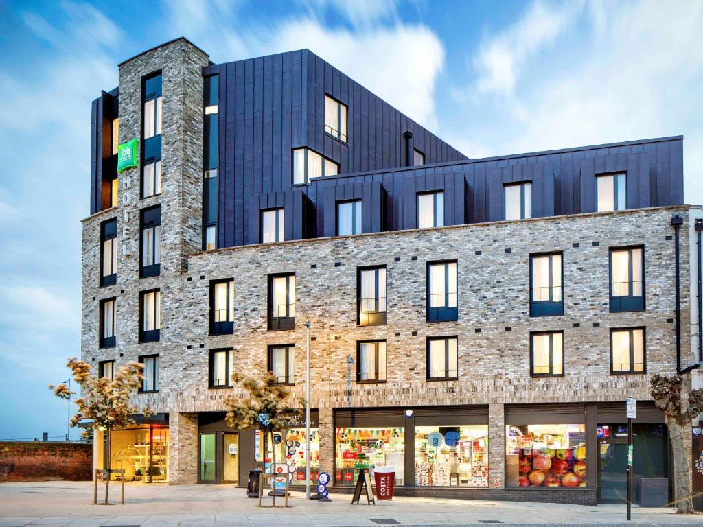 a large brick building with a store front at ibis Styles London Seven Kings in Ilford