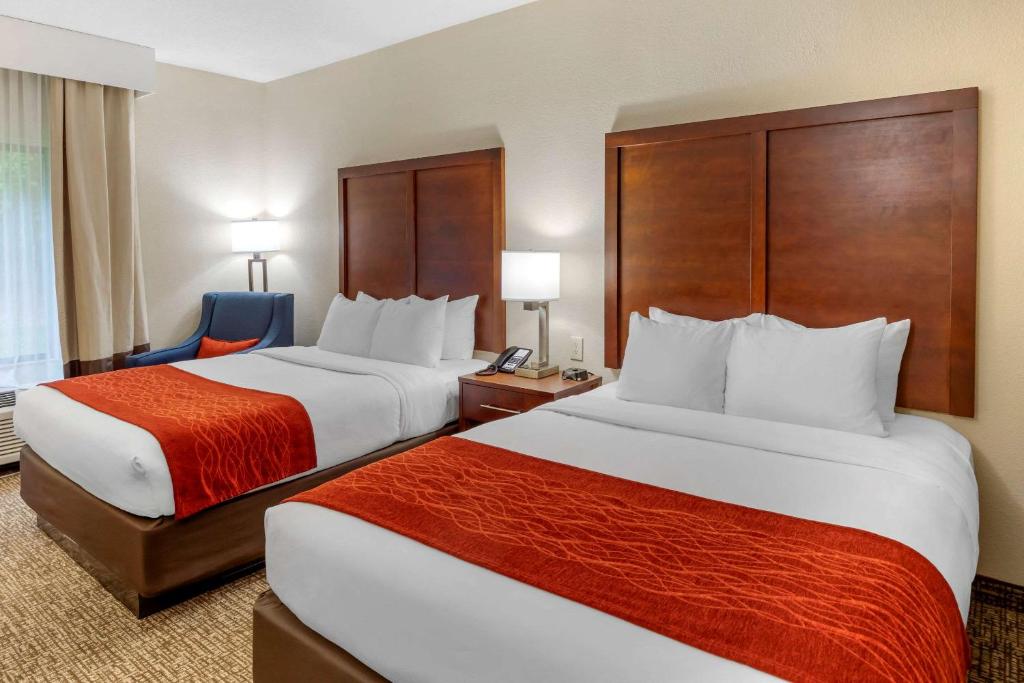 una habitación de hotel con 2 camas y una silla en Comfort Inn & Suites, en Canton