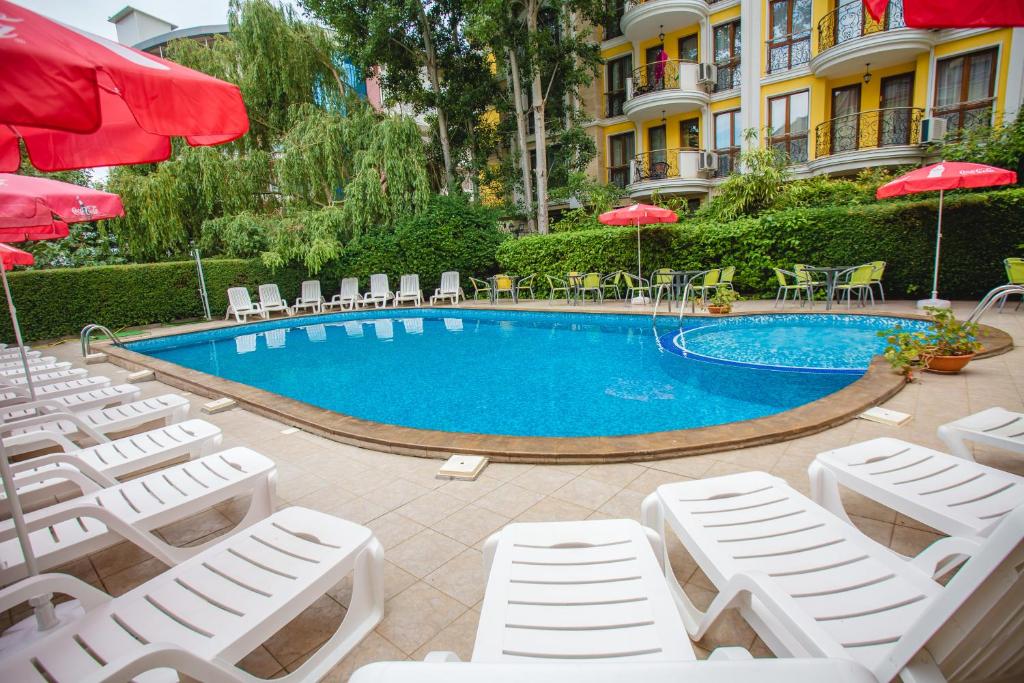 a swimming pool with lounge chairs and umbrellas at Deva Hotel - All Inclusive in Sunny Beach