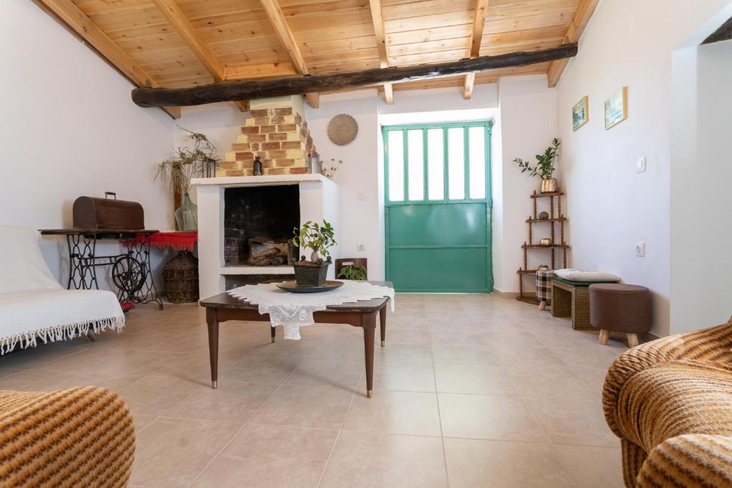 ein Wohnzimmer mit einem Tisch und einem Kamin in der Unterkunft La Casa Cottage in Chania