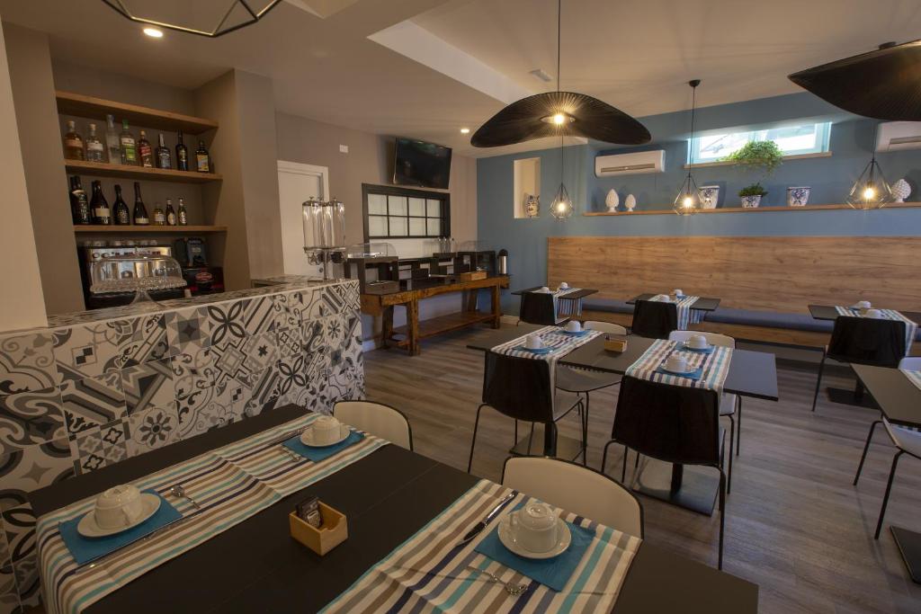 a restaurant with tables and chairs and a bar at Luxmarì Hotel & Spa in Castellammare del Golfo
