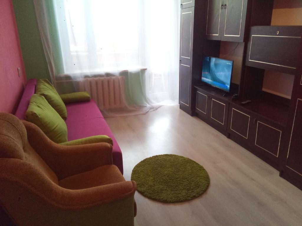 a living room with a purple couch and a tv at Мегацентр in Chernihiv