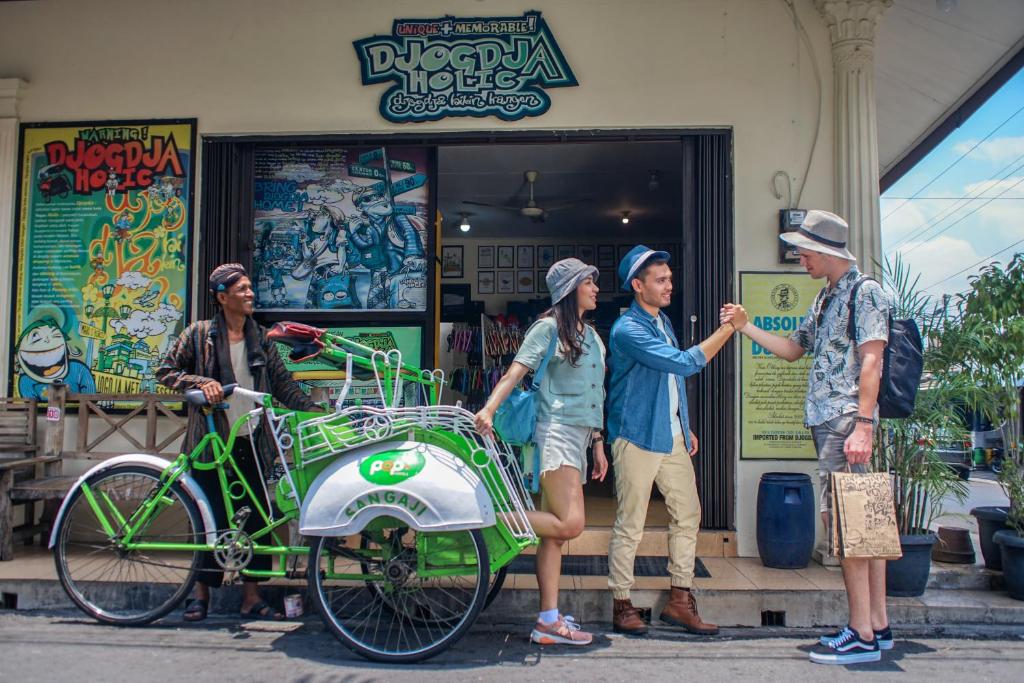 un grupo de personas de pie fuera de una tienda con una bicicleta en POP! Hotel Sangaji Yogyakarta, en Yogyakarta
