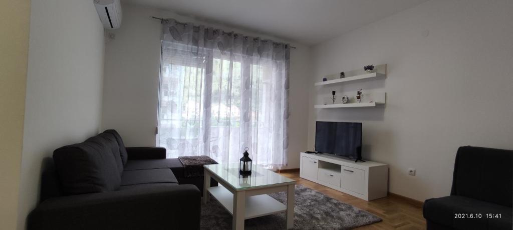a living room with a couch and a table and a window at Apartman Rosić in Trebinje