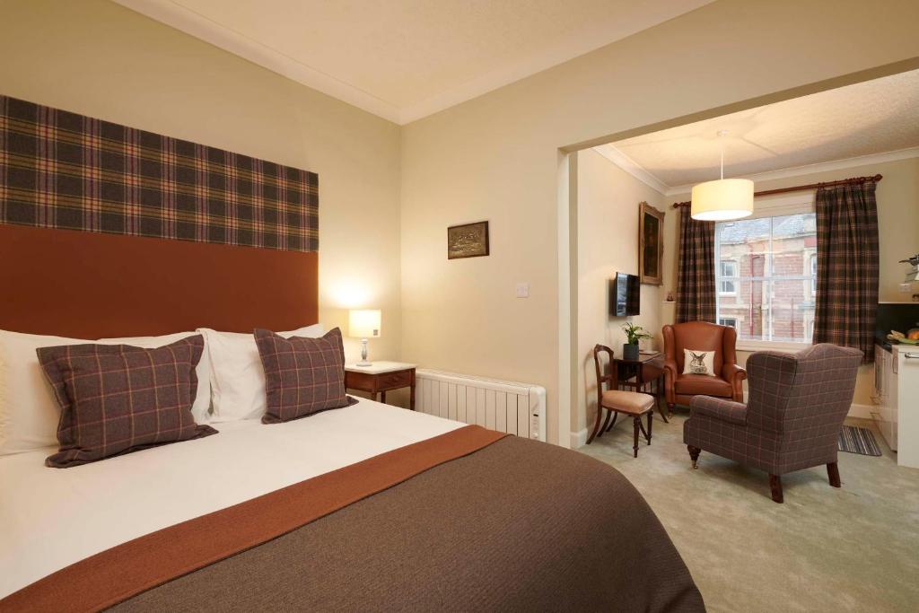 um quarto de hotel com uma cama e uma cadeira em Downright Gabbler em Beauly