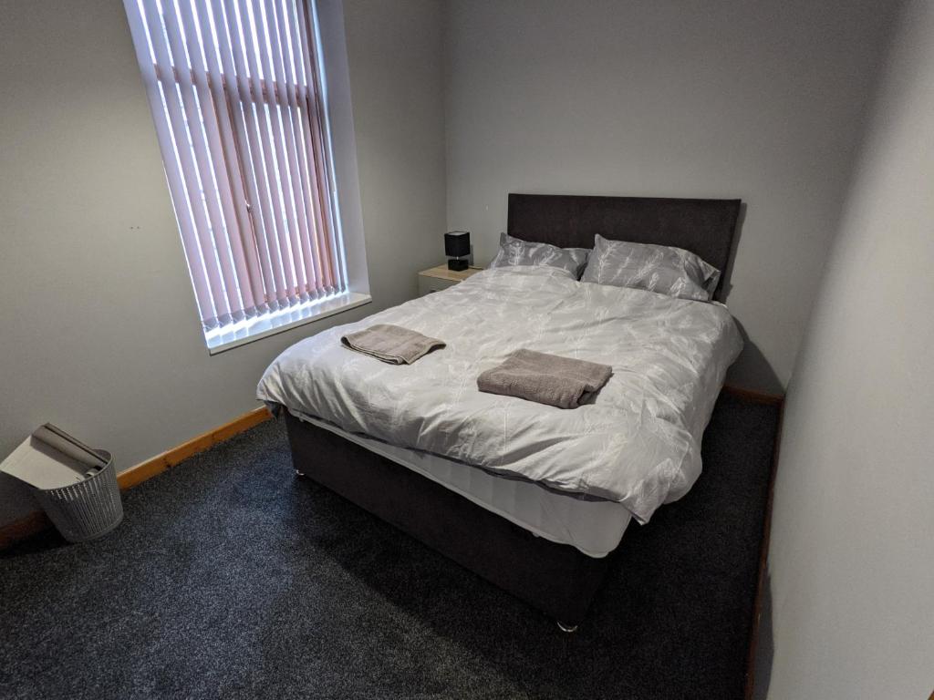 a bedroom with a bed with two towels on it at Cheap and Cosy Rooms with TV in Clayton le Moors