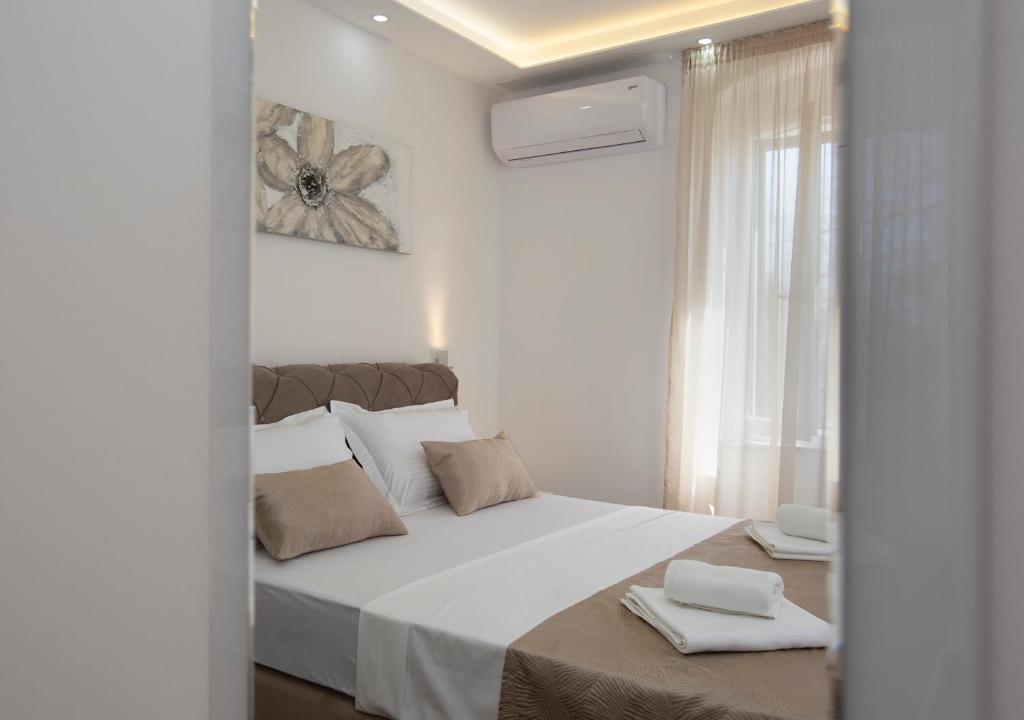 um quarto com uma grande cama branca com duas toalhas em Old town apartment Anamarija em Split