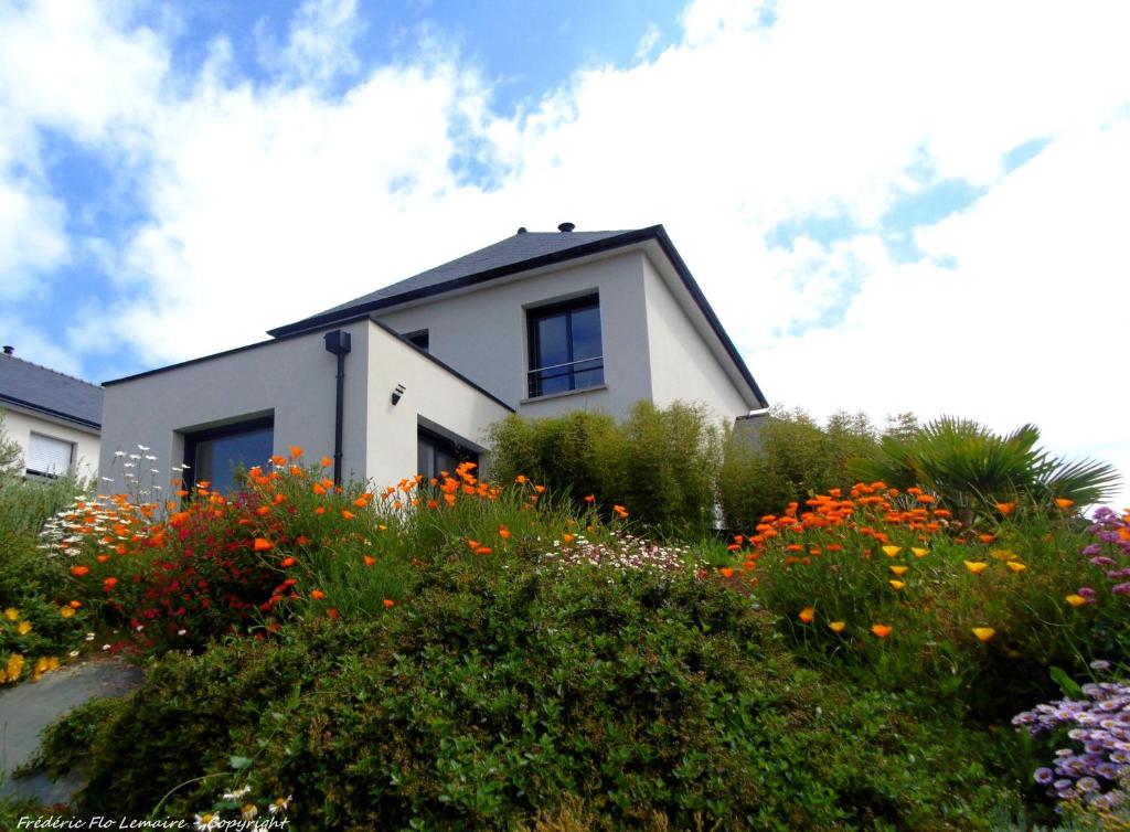 Biały dom z kwiatami przed nim w obiekcie Cap'Houses Ker Marie Amélie w mieście Erquy
