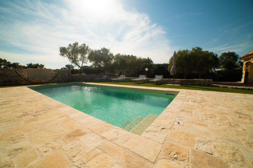- une piscine dans une cour avec une terrasse dans l'établissement Villa Patrizia-Luxury Villa, à Mottola