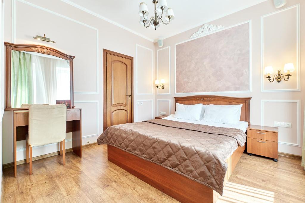 a bedroom with a bed and a desk and a mirror at Palantin Hotel in Saint Petersburg