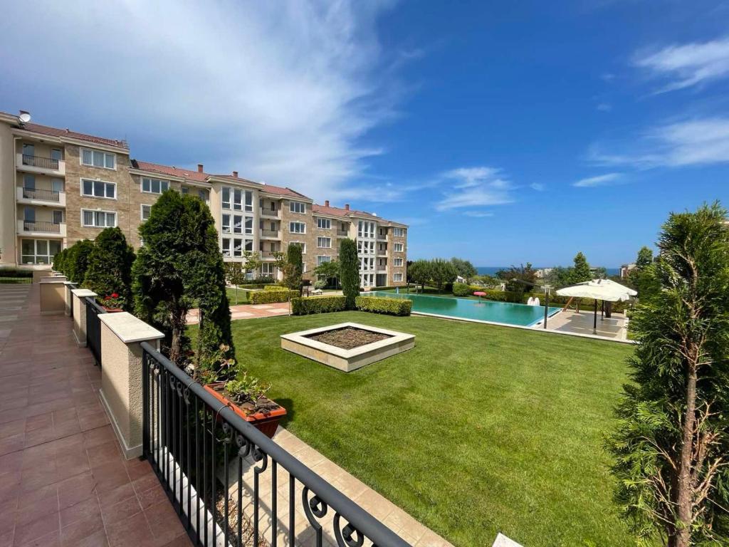a balcony of a apartment complex with a large yard at Provence Deluxe Apartment in Atia Resort in Chernomorets