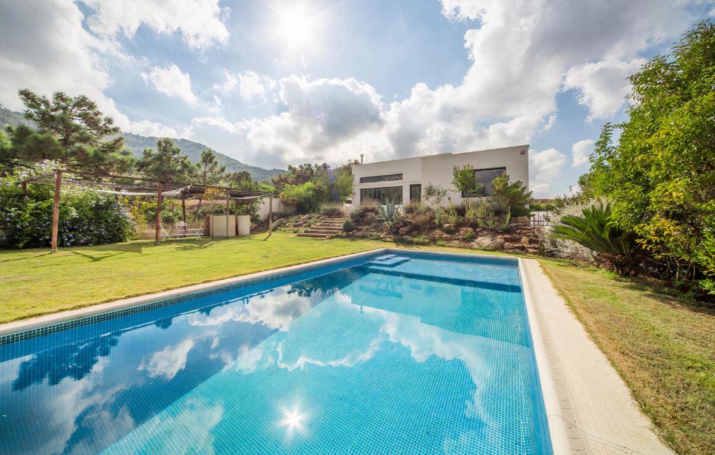 a swimming pool in the backyard of a house at Villa Marmudella in Puebla Tornesa