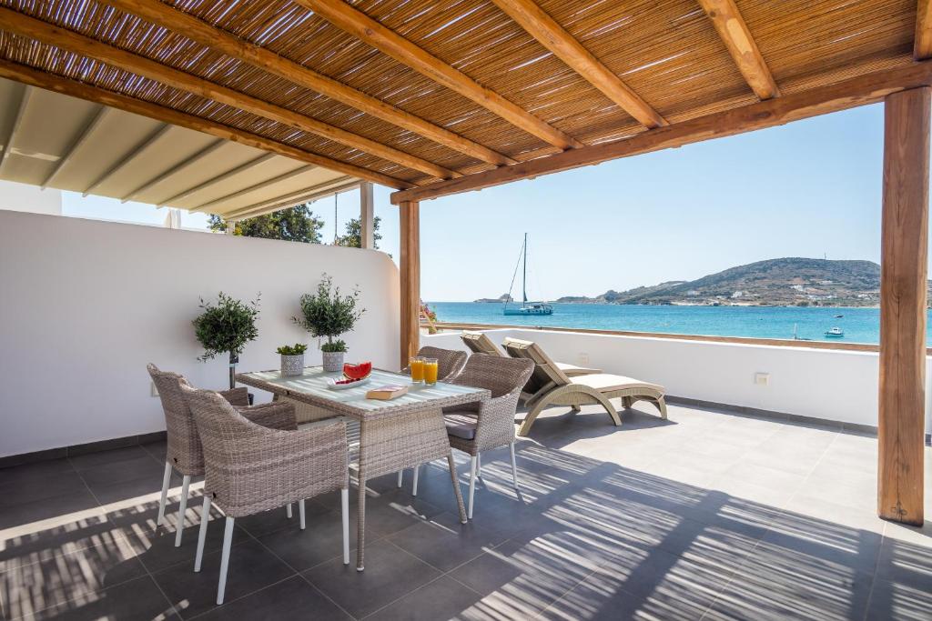 a patio with a table and chairs and a view of the ocean at Michalakis Seaside Suites in Pollonia