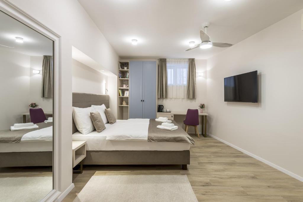 um quarto com uma cama grande e um espelho em COR ROOMS em Split