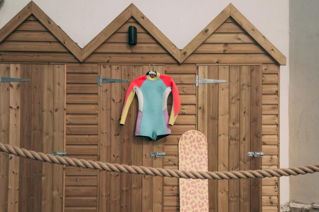 a wooden fence with a jacket and a skateboard at Oceanside Lifestyle Hotel in Newquay
