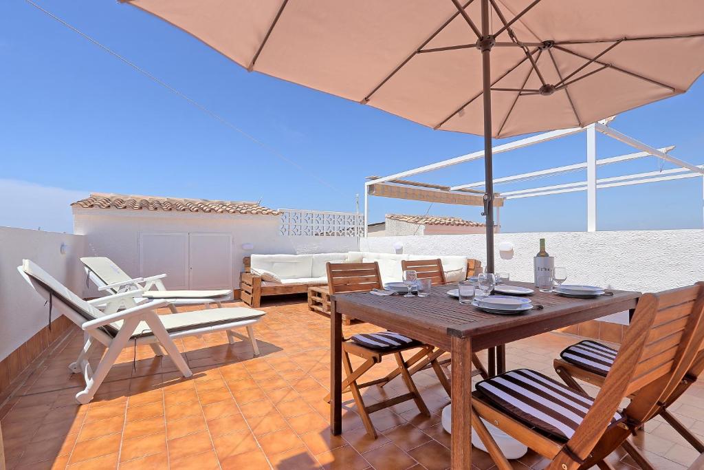 un patio con mesa, sillas y sombrilla en 053 - Altomar II 003 - comfortHOLIDAYS en Gran Alacant