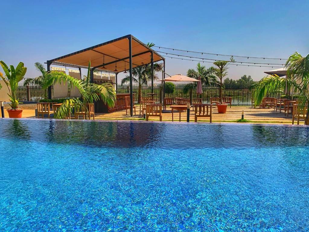 a swimming pool with tables and chairs in a resort at Au bord de l'eau in Bamako